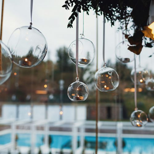 glass-balls-with-candles-hang-before-window